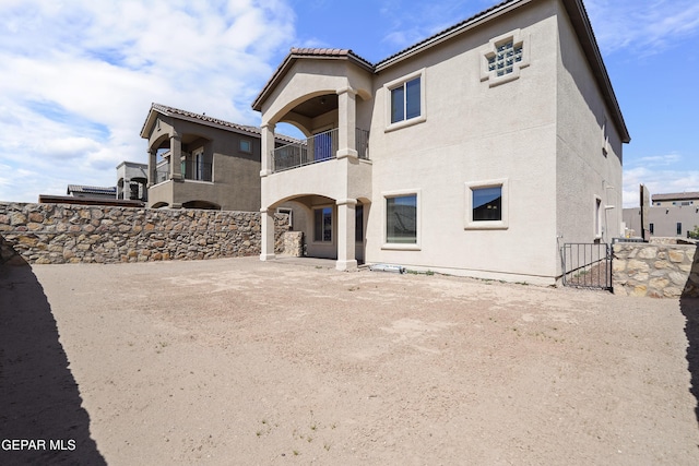 back of property featuring a gate, fence, and stucco siding
