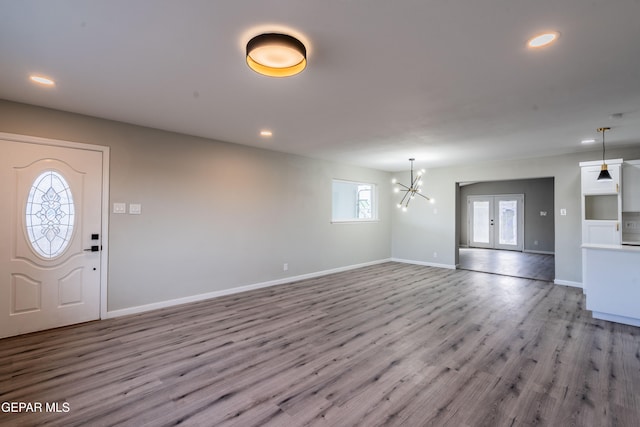 entryway with light hardwood / wood-style flooring, a chandelier, french doors, and plenty of natural light