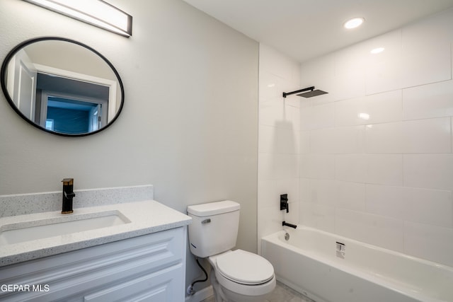 full bathroom featuring vanity, tiled shower / bath, and toilet