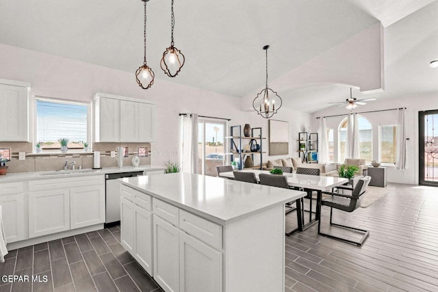 kitchen with dishwasher, ceiling fan with notable chandelier, a healthy amount of sunlight, and white cabinets