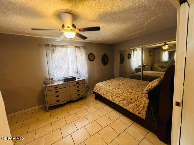 bedroom with a closet, a textured ceiling, and ceiling fan