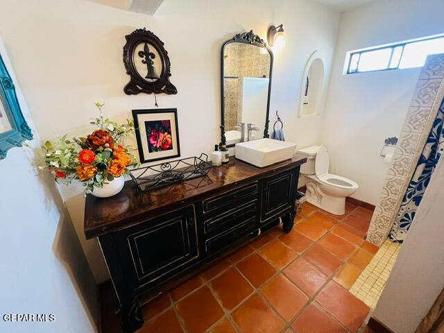 bathroom with tile patterned flooring, vanity, and toilet