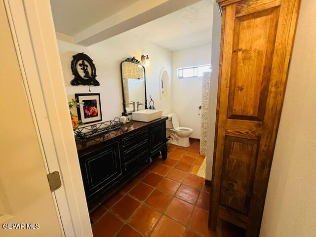 bathroom featuring vanity, tile patterned floors, and toilet