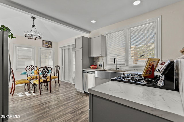 kitchen featuring sink, stainless steel appliances, a notable chandelier, hardwood / wood-style floors, and gray cabinets