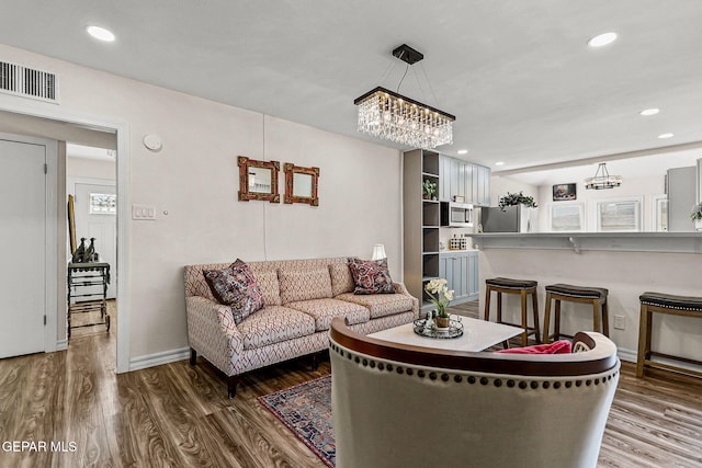 living room with a chandelier, wood-type flooring, and a wealth of natural light