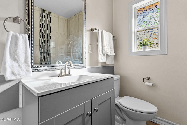 bathroom with vanity, toilet, and plenty of natural light