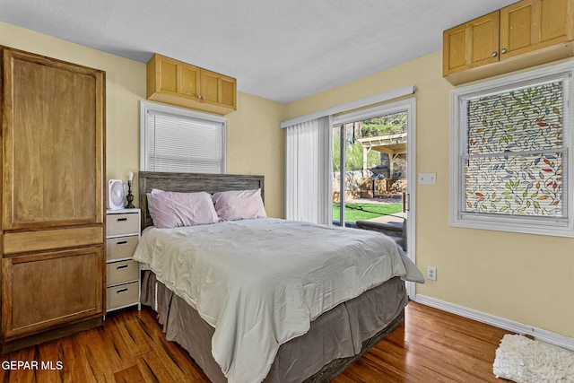 bedroom featuring access to outside and dark hardwood / wood-style floors