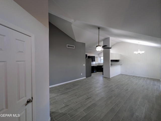 unfurnished living room with ceiling fan with notable chandelier, dark wood-type flooring, and lofted ceiling