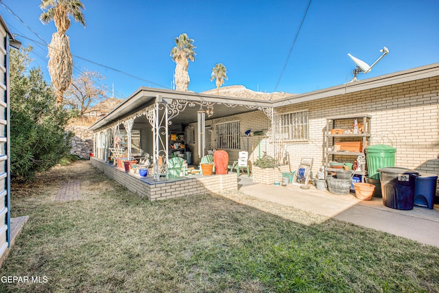 back of property with a yard and a patio