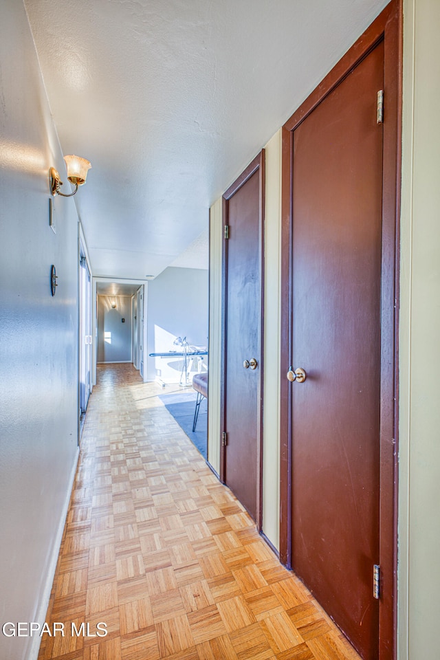 hall featuring light parquet flooring and a textured ceiling