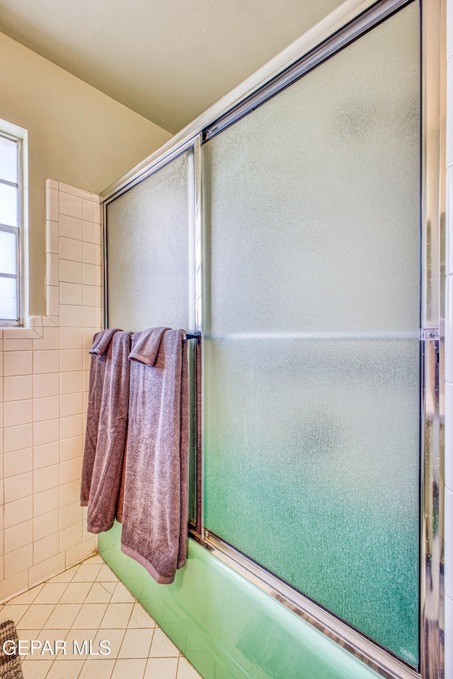 bathroom with shower / bath combination with glass door