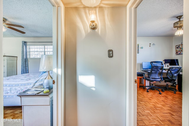 interior space with ceiling fan, parquet floors, and a textured ceiling