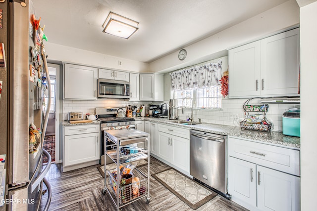 kitchen featuring tasteful backsplash, appliances with stainless steel finishes, sink, and white cabinets