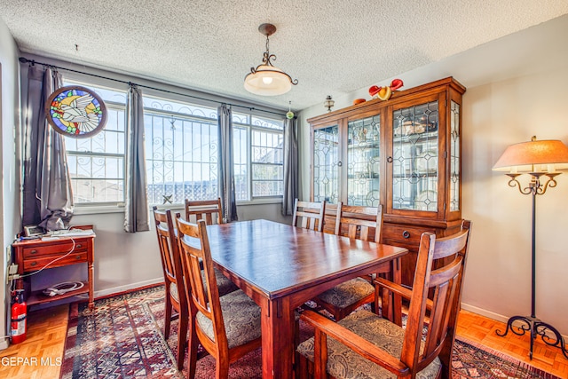 dining room with a textured ceiling, parquet flooring, and a healthy amount of sunlight