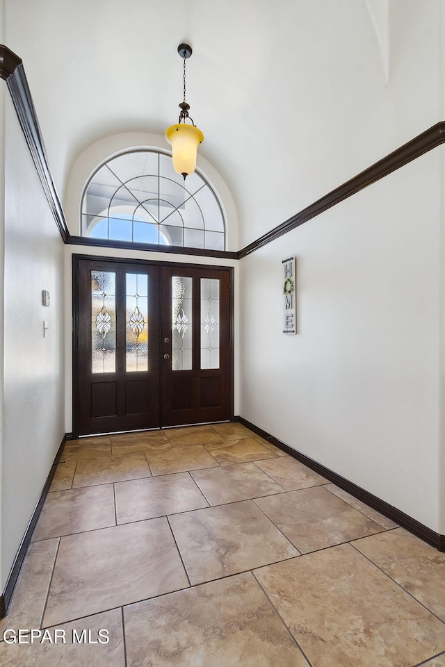 foyer entrance with french doors and high vaulted ceiling