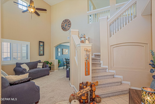 carpeted living room with high vaulted ceiling and ceiling fan