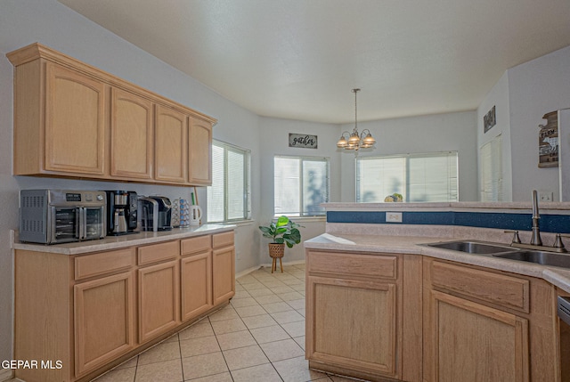 kitchen with sink, light brown cabinets, light tile patterned floors, hanging light fixtures, and a notable chandelier