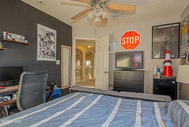 bedroom featuring a textured ceiling, carpet flooring, and ceiling fan