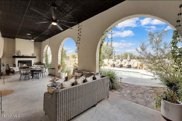 view of patio / terrace featuring an outdoor living space with a fireplace and ceiling fan