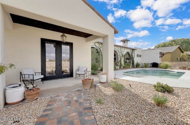 view of pool with french doors and a patio area