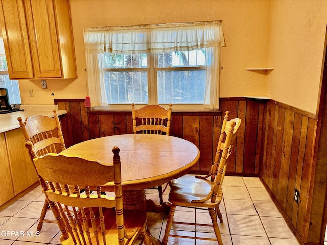 10521 Gaius Dr, El Paso, TX 79924 - dining area featuring plenty of natural light, light tile patterned flooring, wooden walls, and a wainscoted wall