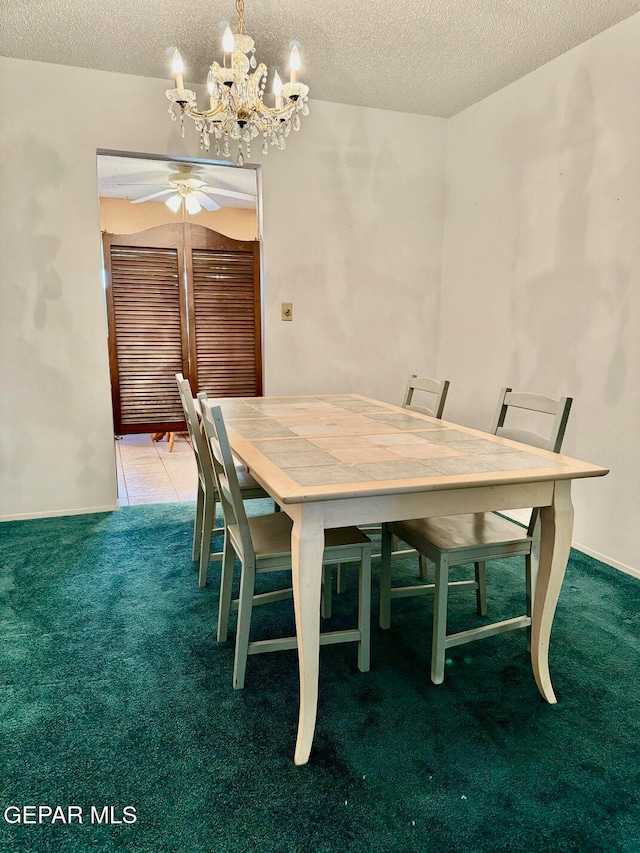 unfurnished dining area with a textured ceiling, carpet flooring, and ceiling fan with notable chandelier