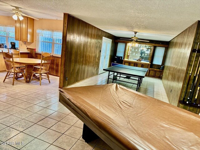 10521 Gaius Dr, El Paso, TX 79924 - recreation room featuring a ceiling fan, wood walls, a textured ceiling, and light tile patterned flooring