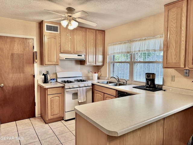 kitchen featuring a textured ceiling, light tile patterned floors, sink, gas range gas stove, and kitchen peninsula