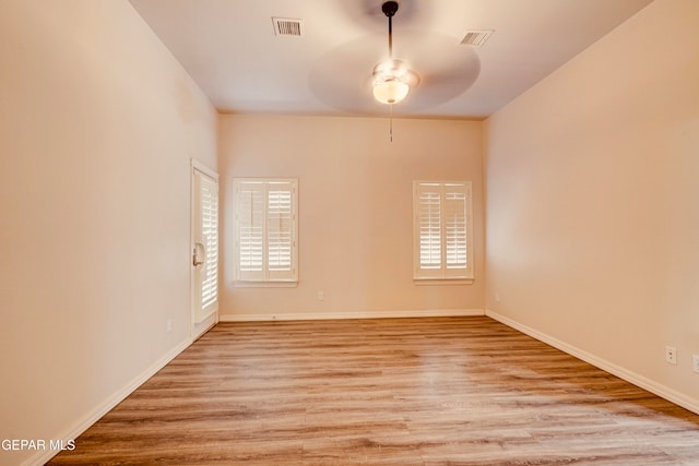 empty room featuring ceiling fan, a healthy amount of sunlight, and light hardwood / wood-style floors