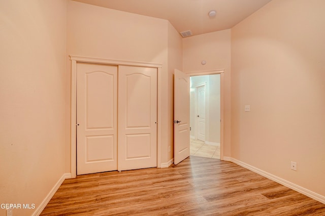 unfurnished bedroom featuring light hardwood / wood-style floors and a closet