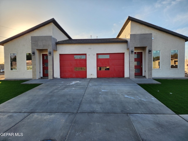 modern home featuring a garage and a lawn