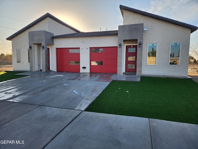 contemporary house featuring a garage and a lawn