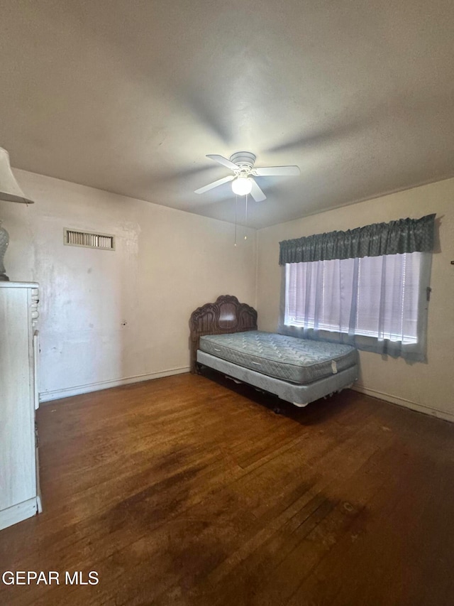 unfurnished bedroom with dark hardwood / wood-style flooring and ceiling fan