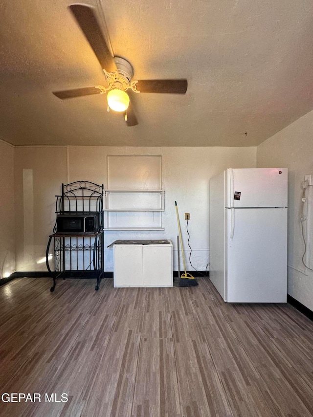 unfurnished bedroom with white refrigerator, a textured ceiling, and hardwood / wood-style flooring