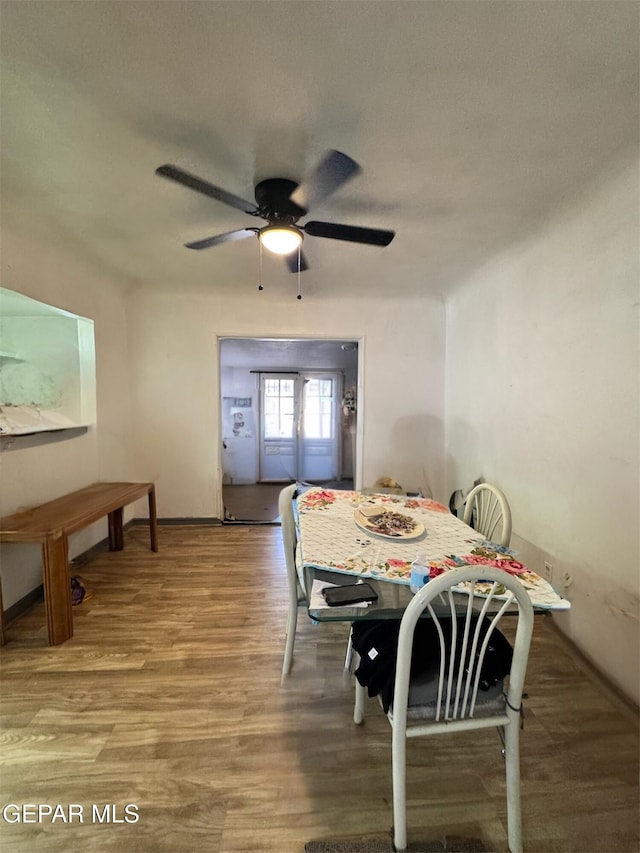 dining area with hardwood / wood-style floors and ceiling fan