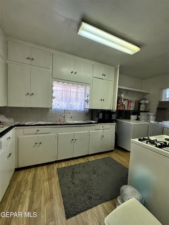 kitchen featuring white cabinetry, sink, backsplash, and light wood-type flooring