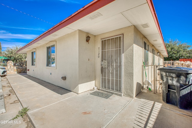 view of exterior entry with a patio area