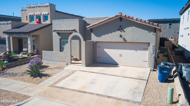 mediterranean / spanish-style house with a garage and central AC