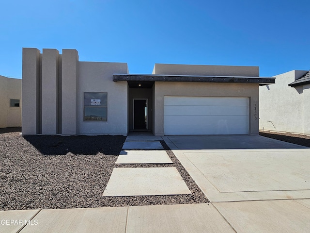 pueblo revival-style home with a garage