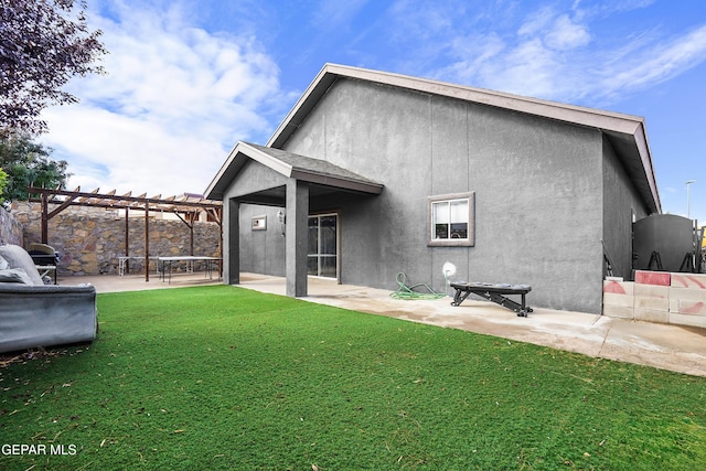 back of property featuring a pergola, a lawn, and a patio