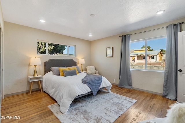 bedroom featuring multiple windows and light hardwood / wood-style flooring