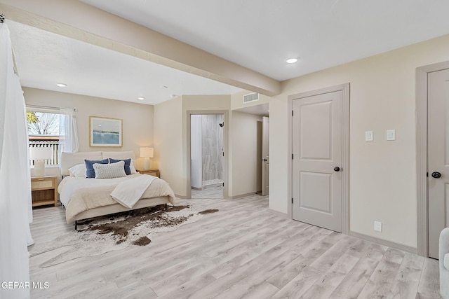 bedroom featuring light hardwood / wood-style floors and ensuite bathroom