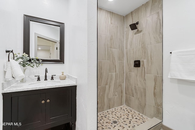 bathroom with vanity and tiled shower