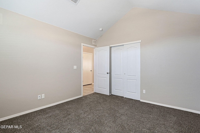 unfurnished bedroom featuring a closet, vaulted ceiling, and carpet flooring