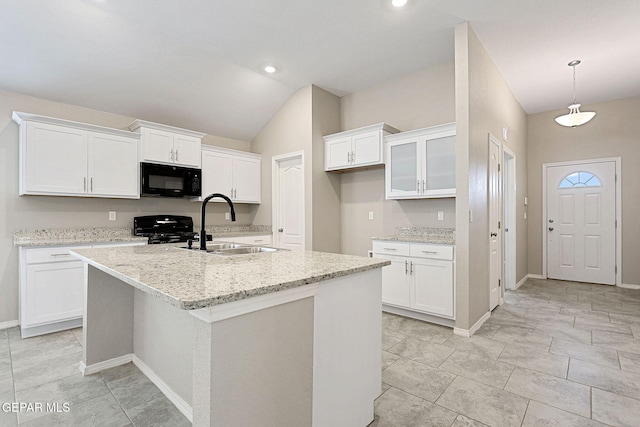 kitchen featuring an island with sink, white cabinetry, black appliances, and vaulted ceiling