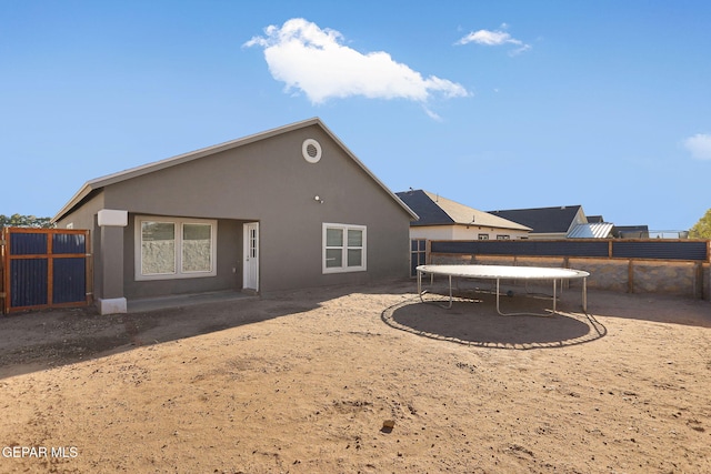 back of house featuring a trampoline