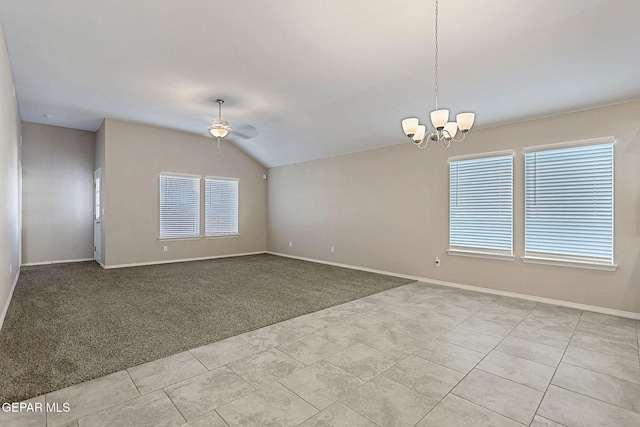 unfurnished room with ceiling fan with notable chandelier, a wealth of natural light, light carpet, and vaulted ceiling