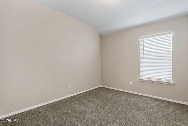 carpeted spare room with vaulted ceiling