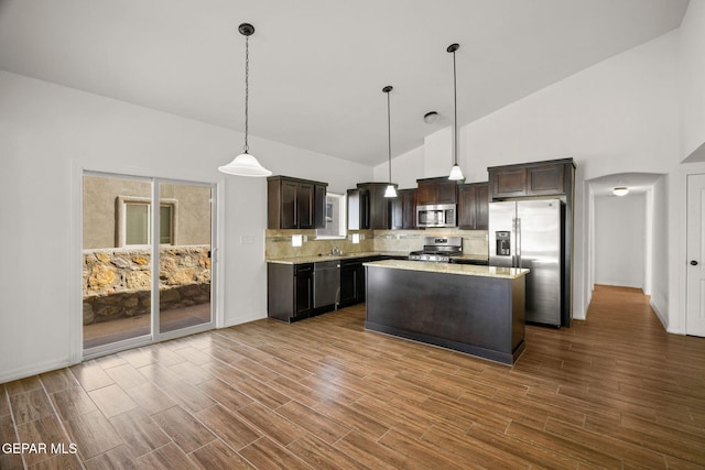 kitchen featuring stainless steel appliances, hardwood / wood-style floors, hanging light fixtures, high vaulted ceiling, and dark brown cabinets