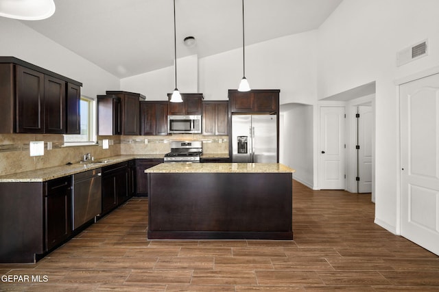 kitchen featuring stainless steel appliances, dark hardwood / wood-style floors, pendant lighting, and high vaulted ceiling